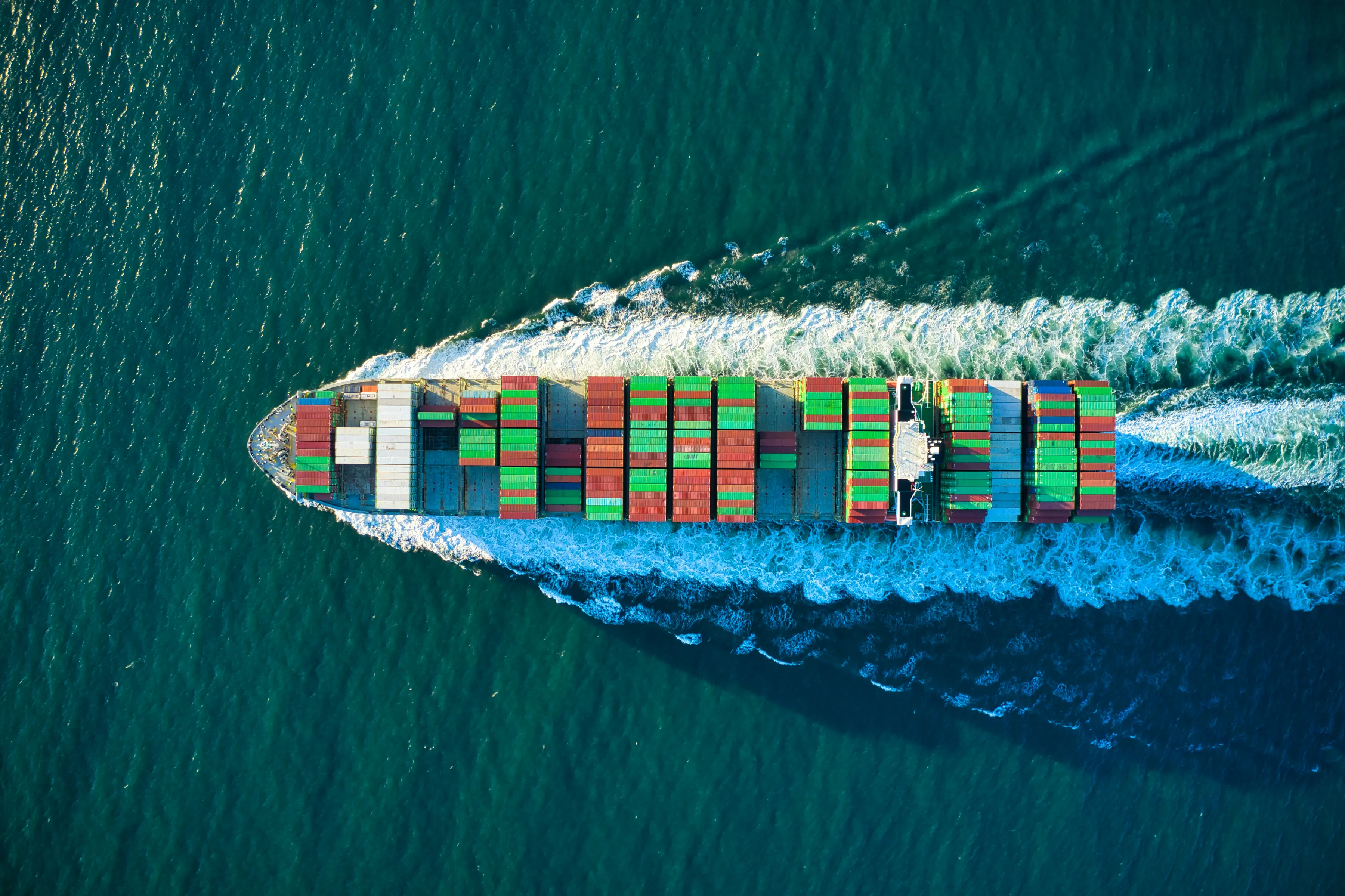 Aerial view of a container ship cutting through open water